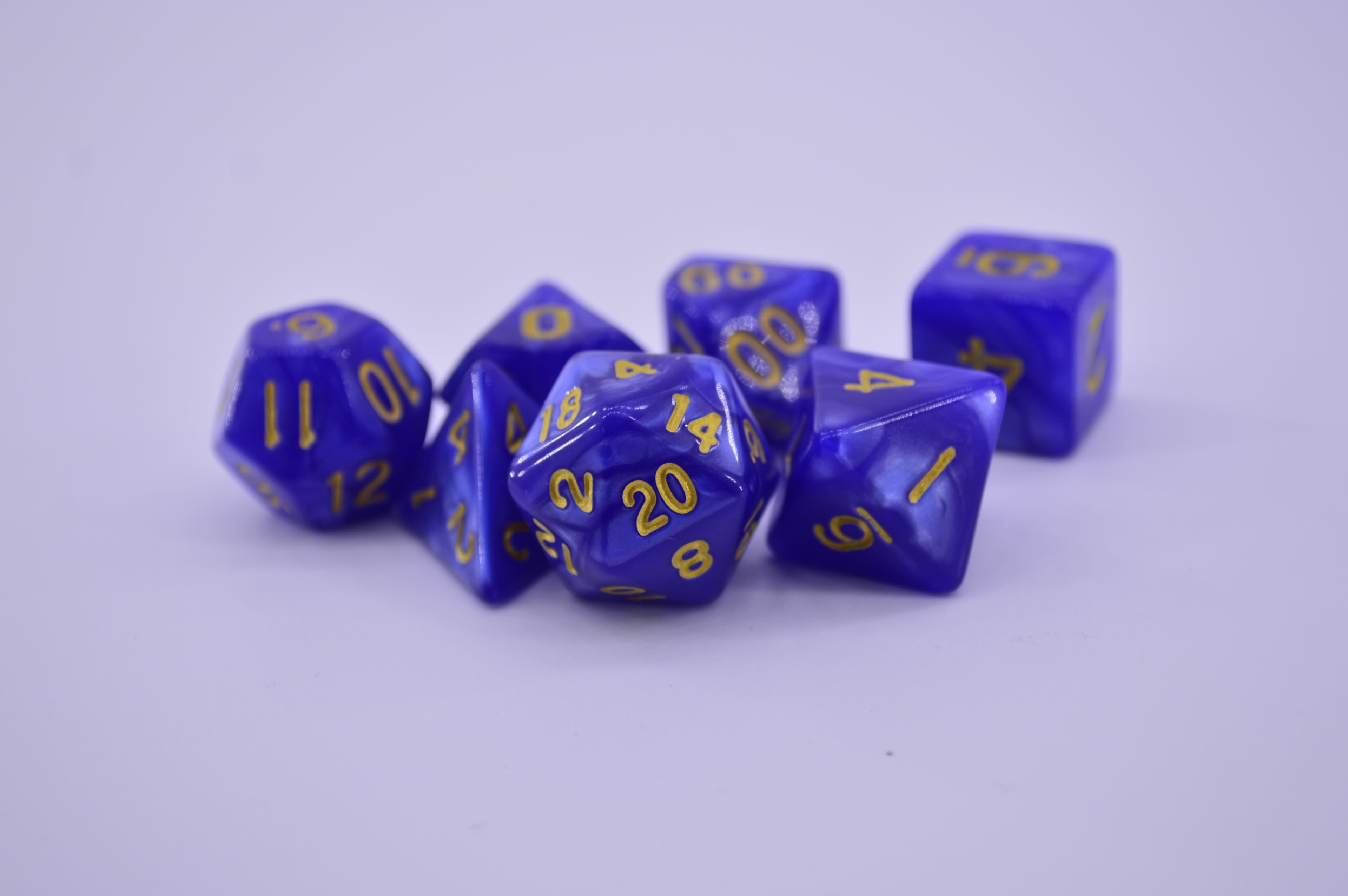 Close-up of purple polyhedral dice on a white surface, perfect for tabletop gaming enthusiasts.